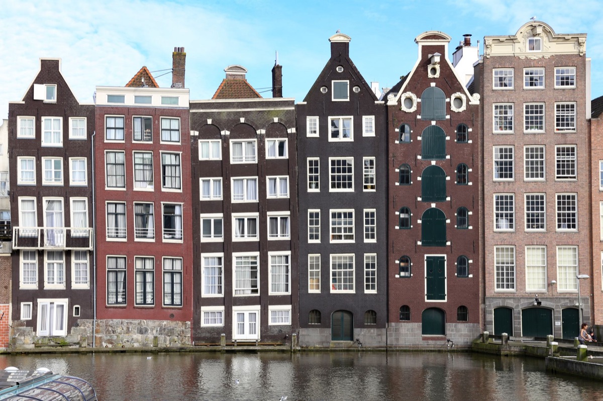 Casas históricas de Amsterdã refletidas na água do canal.