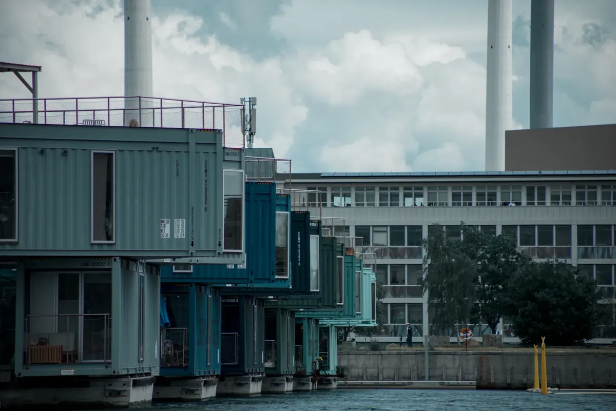 Colorful container homes on an urban waterfront showcasing modern architecture and industrial design.