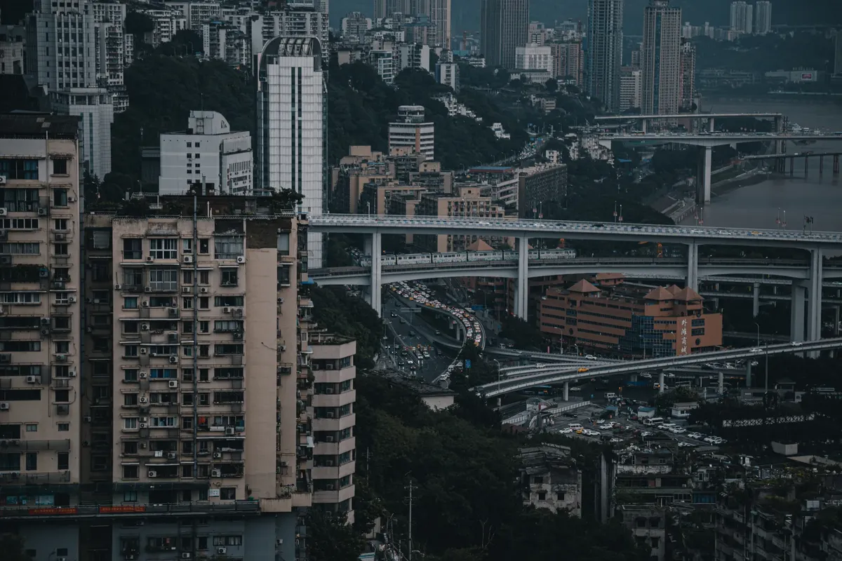Aerial view of Chongqing cityscape showcasing dense urban buildings and intricate highway system.