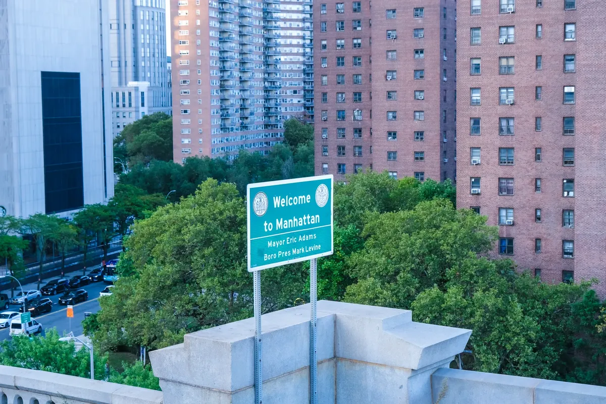 Overview of Manhattan with a welcome sign and urban architecture in New York City.